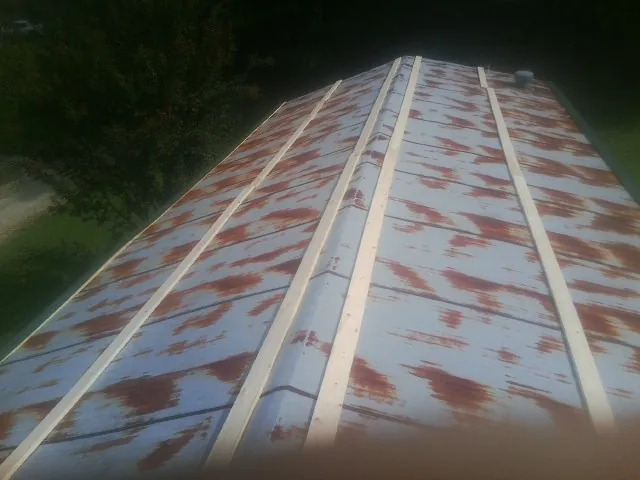 Rusted metal roof panels with new wood purlins before replacement — Storm Damage Roof Repair in Norwood by Roofing Brothers