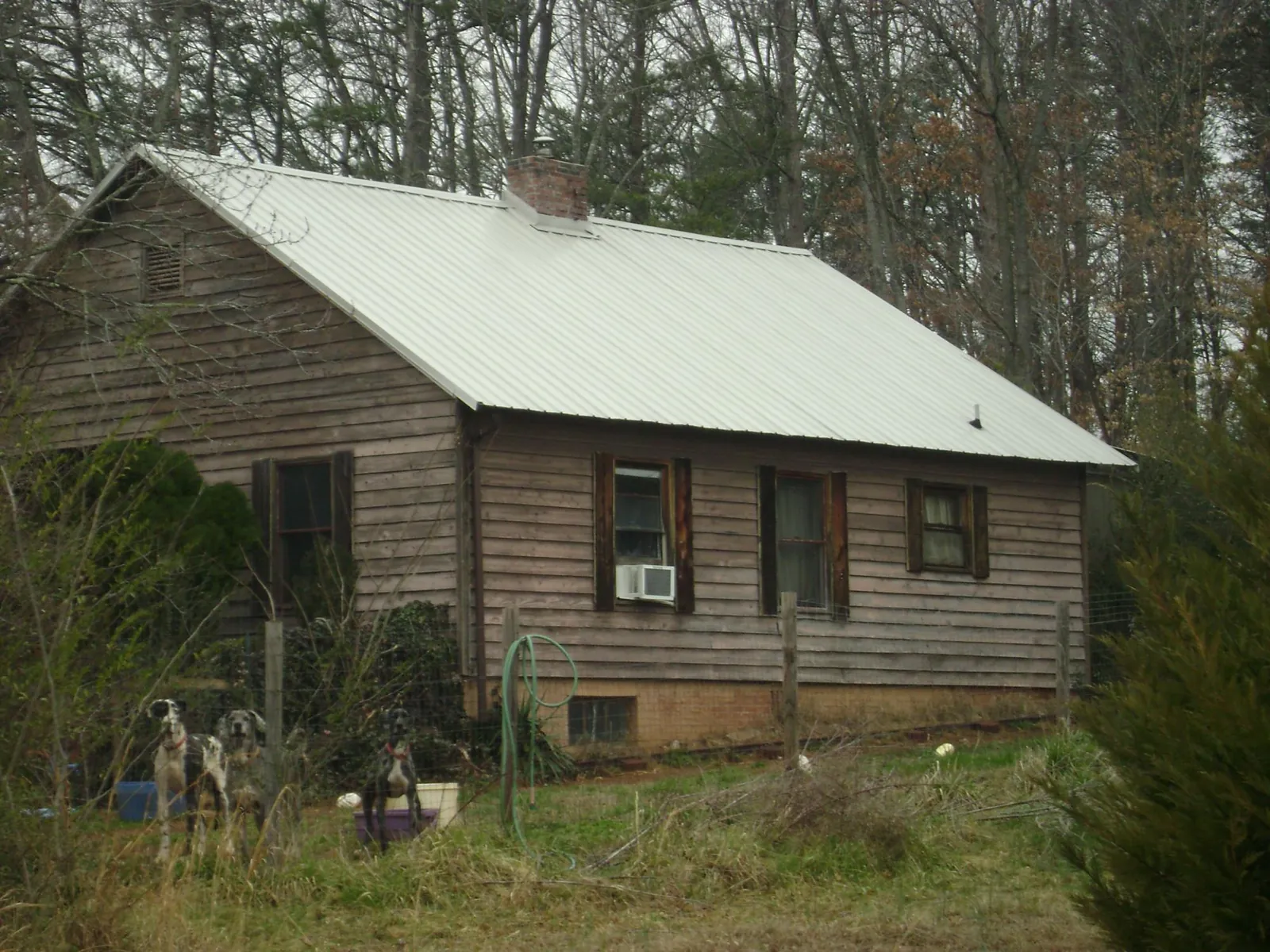 White metal roof on an old wood sided farmhouse, from a Metal Roof Installation job in Norwood